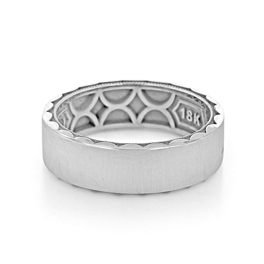 The Tacori Classic Satin Finish 18K White Gold Men's Wedding Band is a thick, silver-colored ring with a smooth outer surface and a patterned inner side. It features a high polished band and its clean, modern design is reminiscent of Tacori's signature sculpted crescent style seen in their engagement rings.