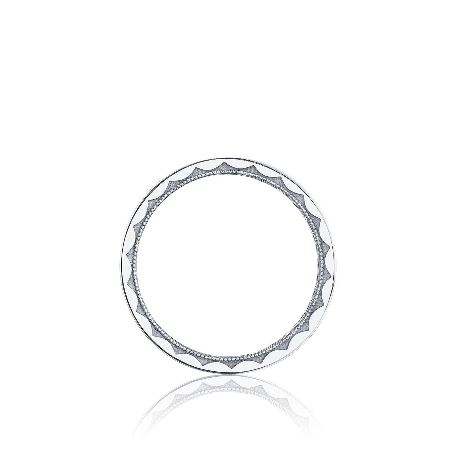 A round, white ceramic plate with a decorative black geometric pattern on the rim echoes the Tacori High Polish Finish 18K White Gold Men's Round Brilliant Diamond Wedding Band by featuring alternating wavy lines and dotted accents. The plate is centered over a white background.