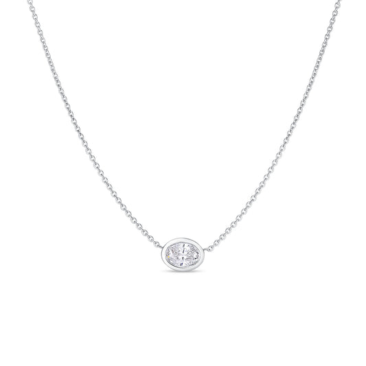 The Roberto Coin Diamonds By The Inch 18K White Gold Large Bezel Set Oval Cut Diamond Necklace Pendant features an elegant silver chain adorned with an oval-shaped diamond pendant. Crafted in luxurious 18k white gold, this necklace showcases a minimalist bezel setting and is beautifully presented against a plain white background.