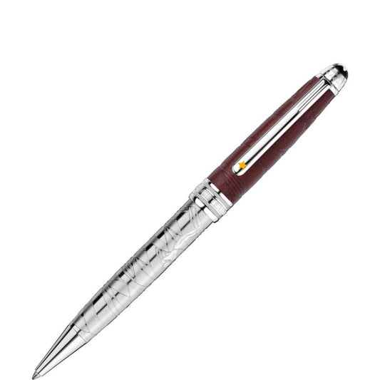 The Montblanc Meisterstuck Le Petit Prince Solitaire Doue Ballpoint Pen from the Montblanc brand features a silver metallic body with intricate engravings and a brown textured grip, showcasing its luxury status. Its midsize ballpoint design is enhanced by a clip adorned with a subtle decorative touch.
