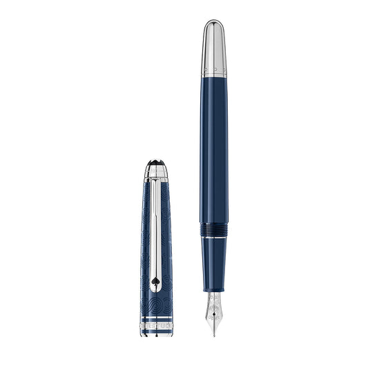 The Montblanc Meisterstück Around the World in 80 Days Classique Fountain Pen is a luxury writing instrument, featuring a sleek blue resin body with a silver nib and cap. The cap is positioned upright, showcasing intricate decorative patterns and a shiny clip, while the pen lies horizontally.
