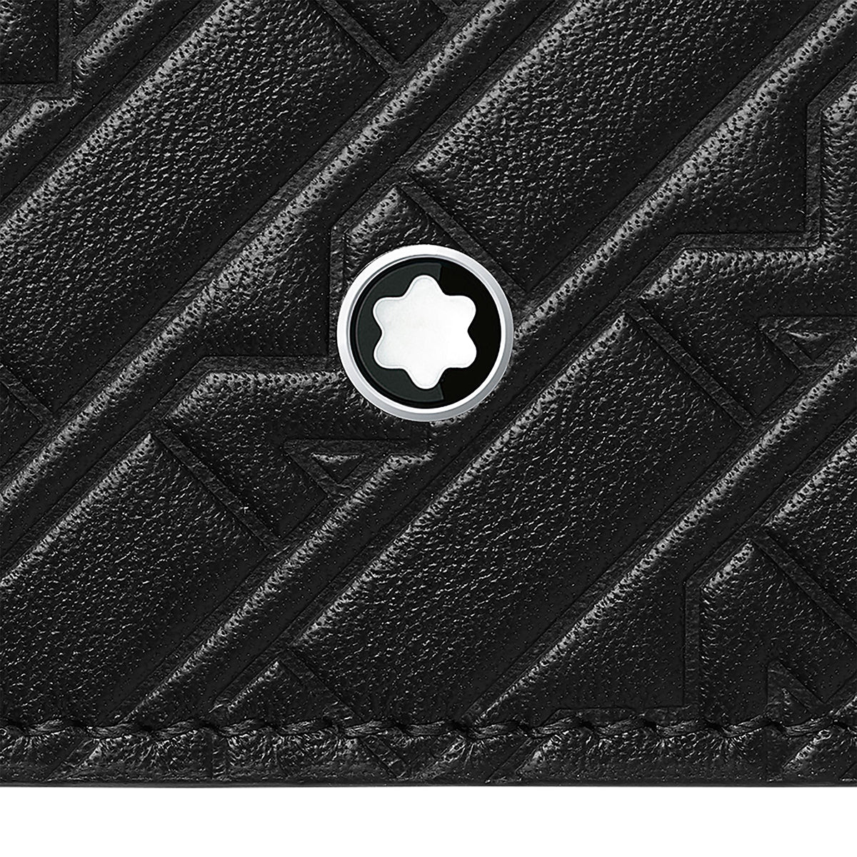 Close-up of the Montblanc M-Gram Leather Wallet 8cc in black textured leather with a chevron pattern, featuring a circular Montblanc metal emblem with a white star embedded in the leather surface.