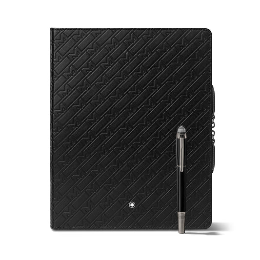 A black leather notebook from the Montblanc Augmented Paper x Montblanc UltraBlack Edition, embossed with a geometric pattern, features a sleek silver pen clipped to the side.