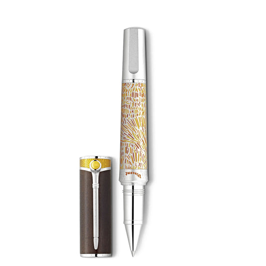 The Montblanc Masters of Art Homage to Vincent Van Gogh Limited Edition 4810 Rollerball Pen, a luxury item featuring a silver clip and an intricate golden pattern on the barrel, along with a cream-colored cap, captures the essence of Van Gogh's Provencal wheatfields. This Limited Edition masterpiece is displayed vertically, with its cap positioned horizontally beside it.