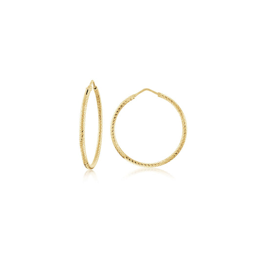 Displayed on a white background are the Miss Mimi Small Diamond Cut 18K Yellow Gold Vermeil and Sterling Silver Hoop Earrings from Miss Mimi by Yael. One earring is shown vertically, while the other is laid flat to highlight its circular shape. Crafted in Italy, these elegant pieces embody classic style and exemplary craftsmanship.