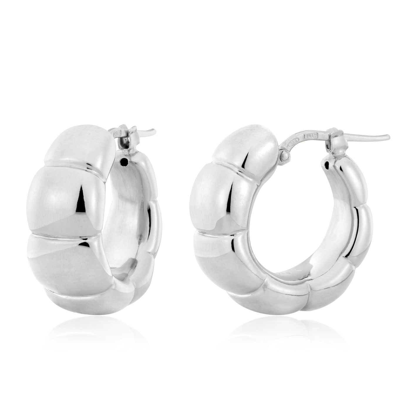 The Miss Mimi Sterling Silver Hoop Earrings by Yael showcase a remarkable segmented design crafted from sterling silver, with a smooth, shiny surface that beautifully reflects light. Made in Italy, these elegant earrings feature a secure latch-back closure and exude sophistication with their metallic finish.