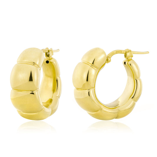 The Miss Mimi by Yael chunky hoop earrings, crafted in 18kt yellow gold vermeil, feature a segmented design. These Miss Mimi 18K Yellow Gold Vermeil Hoop Earrings are displayed against a plain white background, emphasizing their shiny, smooth texture and circular shape.