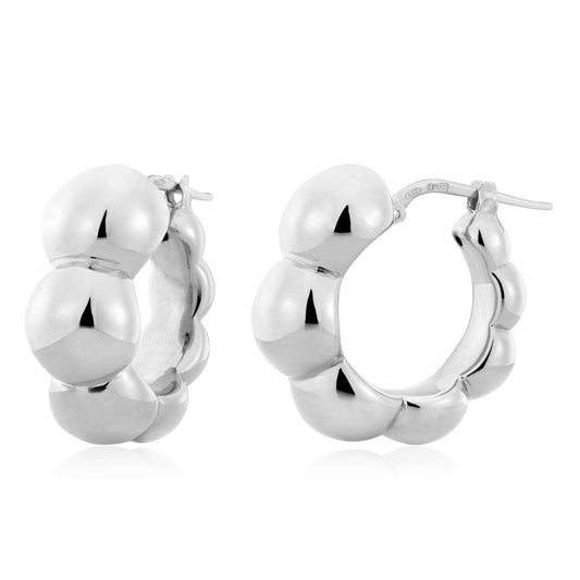 The Miss Mimi Sterling Silver Beaded Hoop Earrings, from the Miss Mimi by Yael collection, feature a rounded, bubble-like design with a polished finish against a plain white background. Made in Italy, these earrings offer a shiny and elegant appearance.