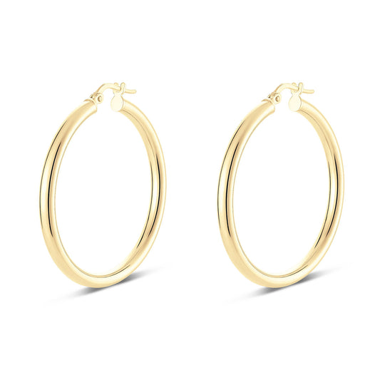 Displayed against a plain white background, the Miss Mimi 18K Yellow Gold Vermeil and Sterling Silver Medium Round Tube Hoop Earrings by Miss Mimi by Yael boast a stunning design with a smooth, reflective finish. With their 35mm diameter and hinged closures, these earrings cast subtle shadows beneath them.