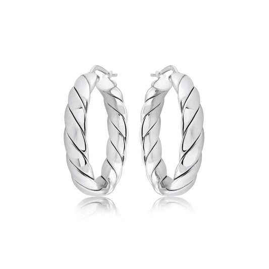 A pair of Miss Mimi Sterling Silver Medium Wrap Quilt Hoop Earrings by Miss Mimi by Yael are displayed against a white background. The earrings, designed with a thick structure and Rhodium bonding, feature a polished, reflective surface with a spiral texture and are elegantly positioned to showcase their sophisticated style.