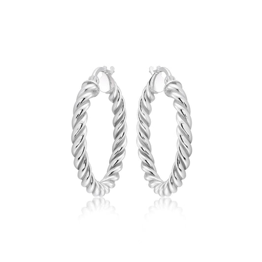 The Miss Mimi Sterling Silver Small Twist Earrings by Miss Mimi by Yael beautifully reflect light against a white background. Crafted from sterling silver, their twisted design offers a textured and shiny appearance.