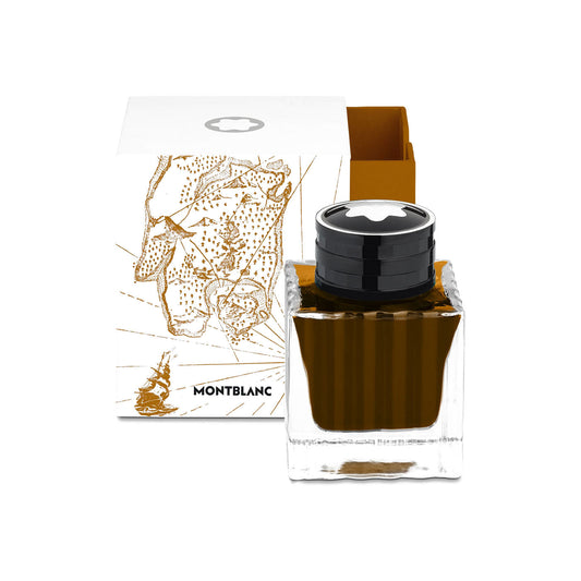 A 50ml Montblanc Ink Bottle featuring a square glass design with a black cap is placed in front of a white box highlighted by a brown illustrated map, evoking the adventurous spirit of Robert Louis Stevenson. The box prominently showcases the Montblanc logo.