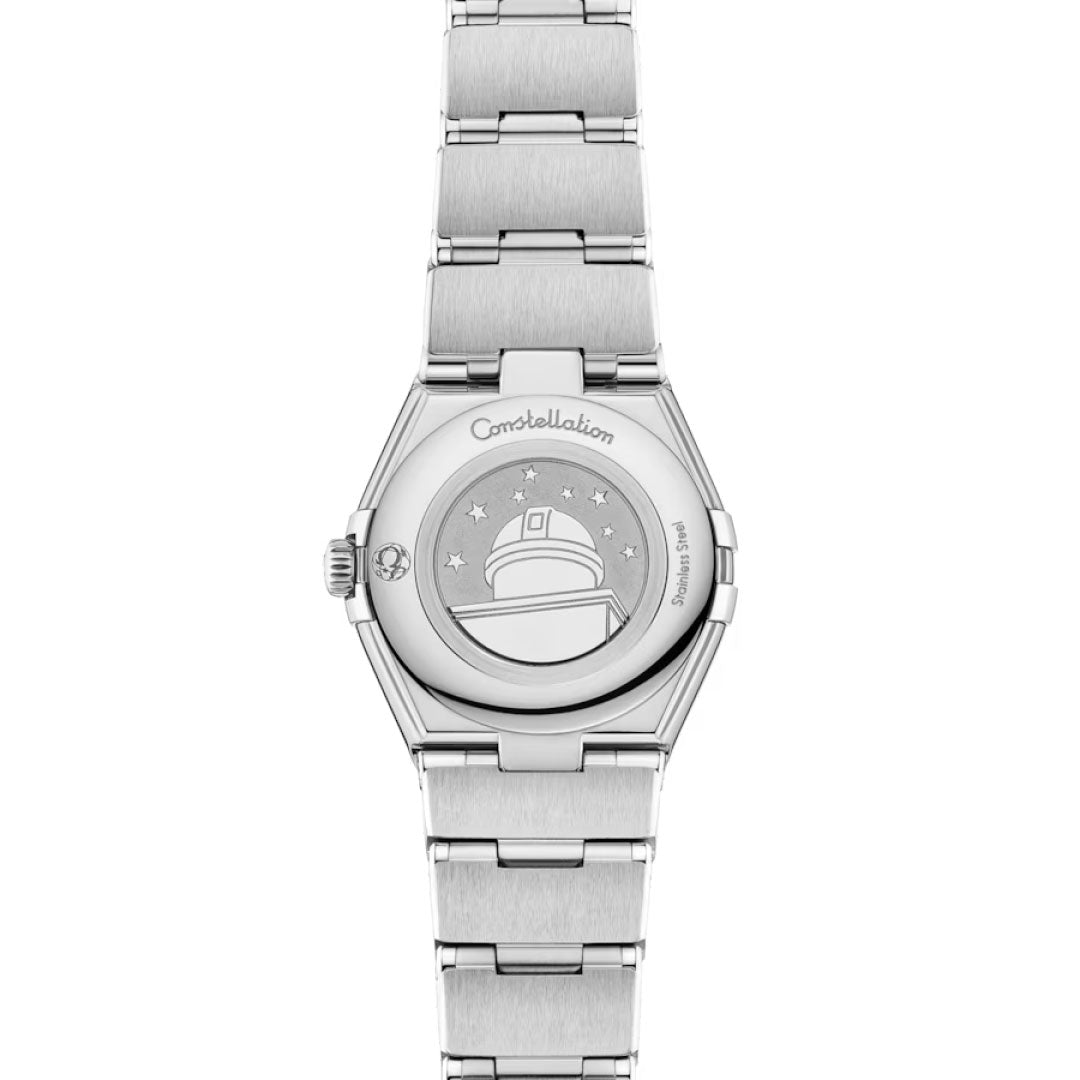 The image shows the back of an OMEGA Constellation Quartz 25mm Watch with an engraved observatory dome, stars, and "Constellation" on the caseback, plus a brushed metal bracelet and a luxurious diamond-paved bezel.