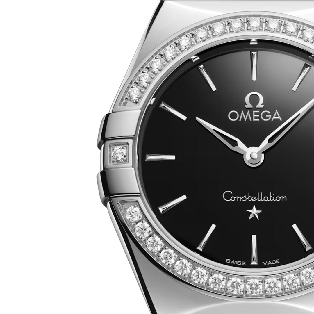 Close-up of the OMEGA Constellation Quartz 28mm Watch in stainless steel, featuring a black dial, silver hour markers and hands, a diamond bezel, and visible OMEGA logo with "Constellation" on the face.
