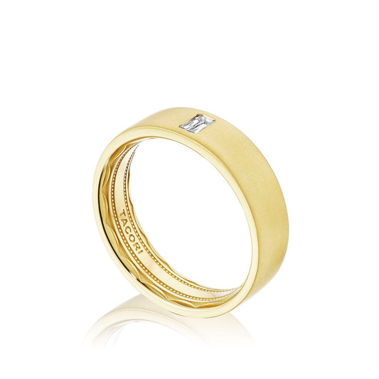 The Tacori Satin Polish Finish 18K Yellow Gold Round Brilliant Bezel Set Diamond Wedding Band features a single round brilliant diamond set into the band, highlighting Tacori’s signature sculpted crescent detail inside. Delicate artistry fills the interior with the "Tacori" brand name engraved, while its satin finish elegantly complements the gold against a white background.