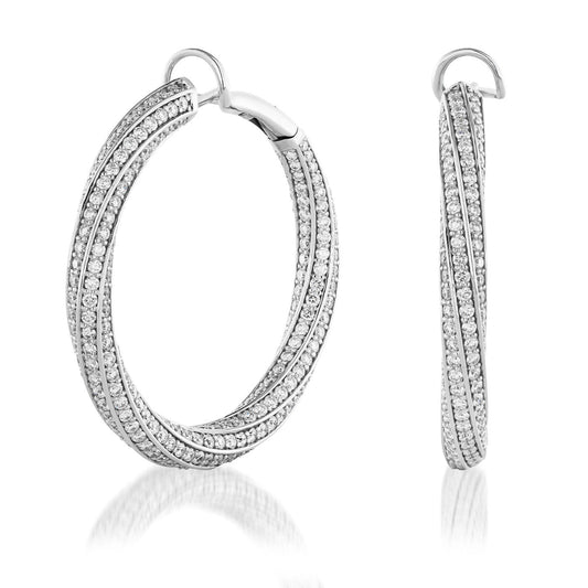 Introducing the Raffi&Co.® 18K White Gold Diamond Hoop Earrings, a stunning pair of hoop earrings featuring a twisted design crafted in exquisite white gold and embellished with glittering pavé diamonds, elegantly displayed against a white background.