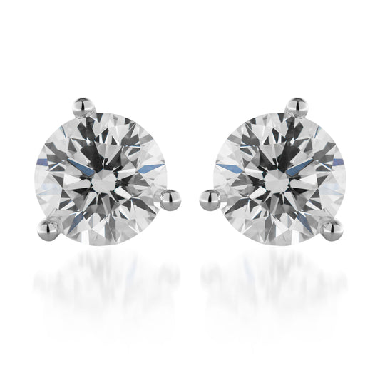 The Raffi&Co.® 14K White Gold Diamond Stud Earrings feature a pair of round diamonds, each set in a classic martini design, with clear and sparkling stones that capture light beautifully. These earrings epitomize timeless elegance and are showcased on a plain white background.