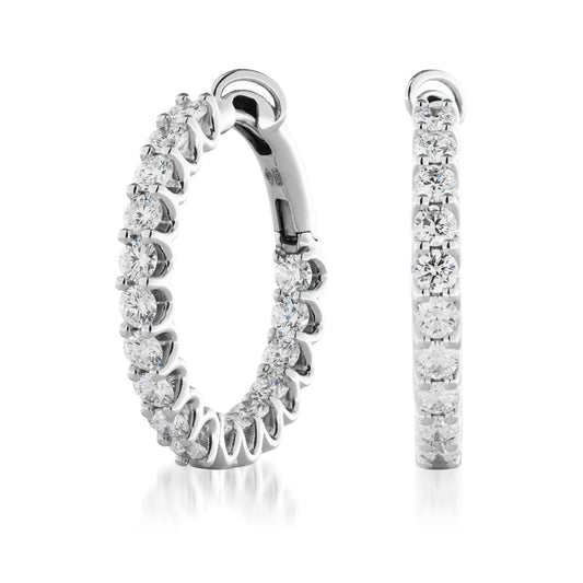 Close-up of the chic Raffi&Co.® 18K White Gold Diamond Hoop Earrings, featuring dazzling hand-set diamonds that exude brilliance and glamour. Displayed from a front and side angle against a white background.