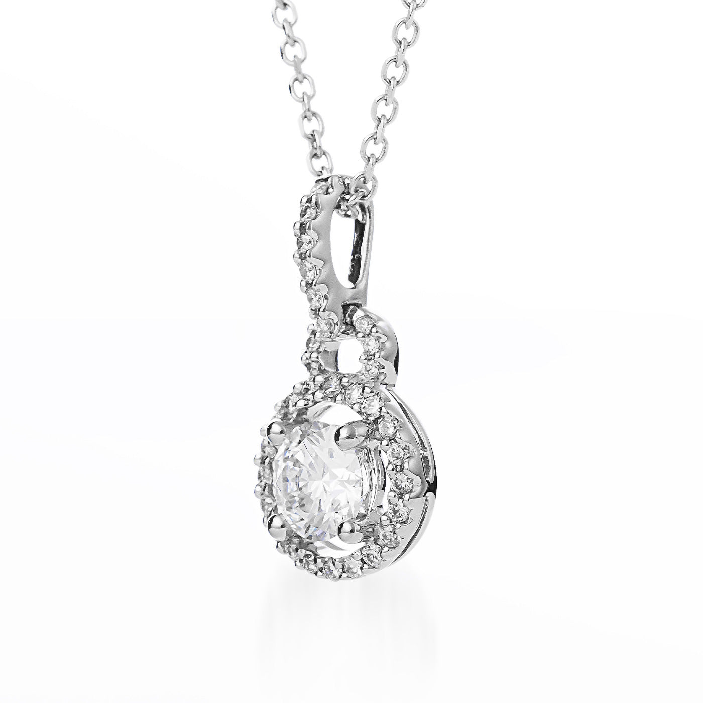 The Raffi&Co.® 18K White Gold Round Brilliant Lab Centre Diamond Necklace Pendant features a stunning central lab-grown diamond, beautifully encircled by smaller mined accent diamonds. The pendant is elegantly suspended from a delicate chain.