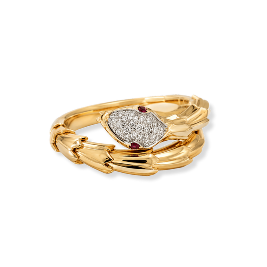 The Raffi&Co.® 18K Yellow Gold Diamond Serpent Ring by Raffi&Co features a snake-shaped design with a diamond-encrusted head set with 0.15 CTW round cut diamonds and two small red gemstone eyes, elegantly coiled in a spiral against a plain white background.