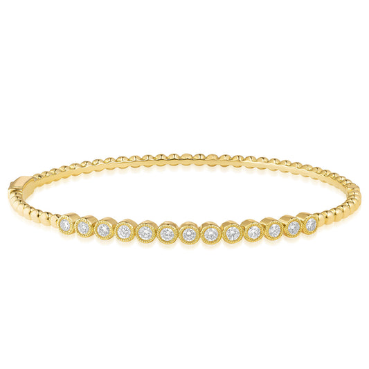 Introducing the Raffi&Co.® 18K Yellow Gold Diamond Bracelet by Raffi&Co, a stunning piece featuring a series of beautifully arranged round diamond accents along its length. The textured band adds an elegant touch to its design, while the bracelet gracefully tapers at the clasp for a delicate and refined style.