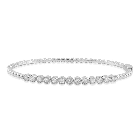 Introducing the Raffi&Co® 18K White Gold Diamond Bangle, a stunning bracelet adorned with small round diamonds set in a bezel design. The elegant and polished band, crafted from 18K white gold, features a secure clasp for a seamless blend of sophistication and simplicity.