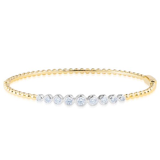 The Raffi&Co.® 18K Yellow Gold Diamond Bracelet showcases a row of small, sparkling diamonds set in silver along the top. The band is crafted with small gold spheres, creating a delicate and elegant design.