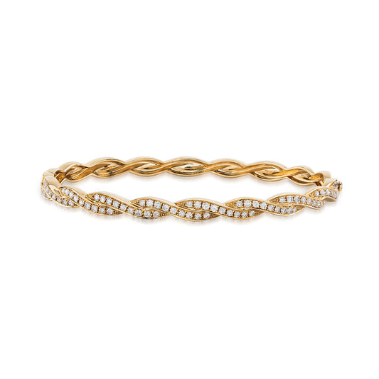 The Raffi&Co.® 18K Yellow Gold Round Brilliant Diamond Bangle features a twisted design with diamonds set in a wavy pattern, offering an elegant and luxurious look.