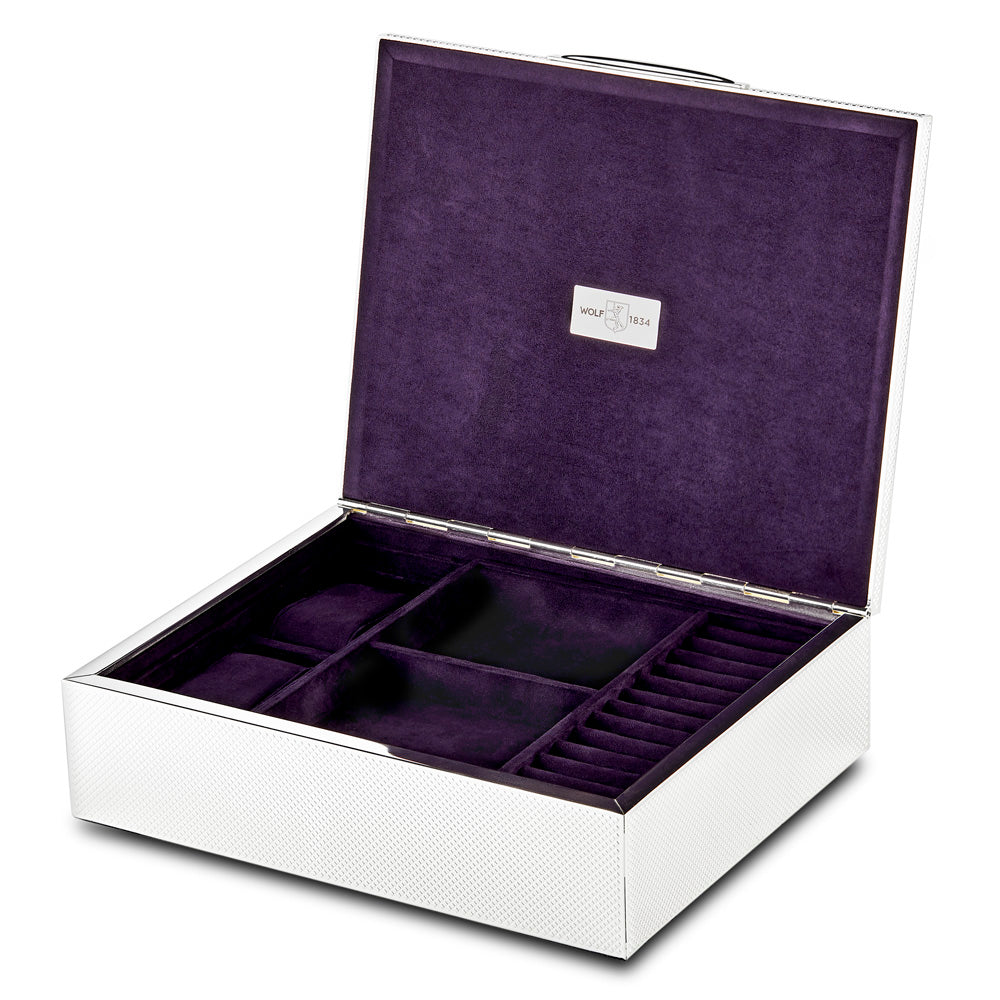 The WOLF 1834 Silver Watch Jewellery and Legacy Box by WOLF is an open, white box with a textured exterior and a plush ultrasuede-lined interior. It boasts silver-plated accents and has several storage compartments for organizing items, including a dedicated section for rings on the right.