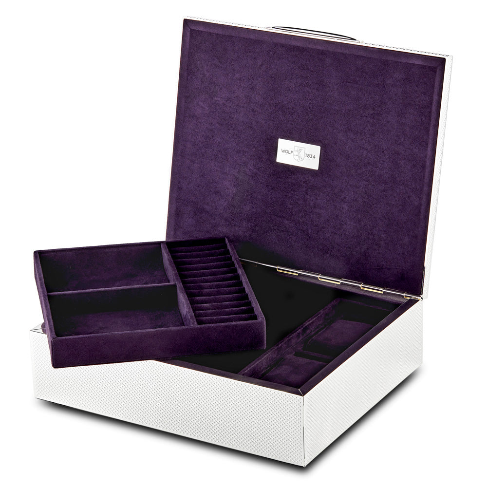 The WOLF 1834 Silver Watch Jewellery and Legacy Box by WOLF is a luxury open storage box boasting a textured white exterior and a dark purple velvet interior. It includes ultrasuede-lined, segmented compartments perfect for organizing various items, and is completed with a small metallic label inside the lid.