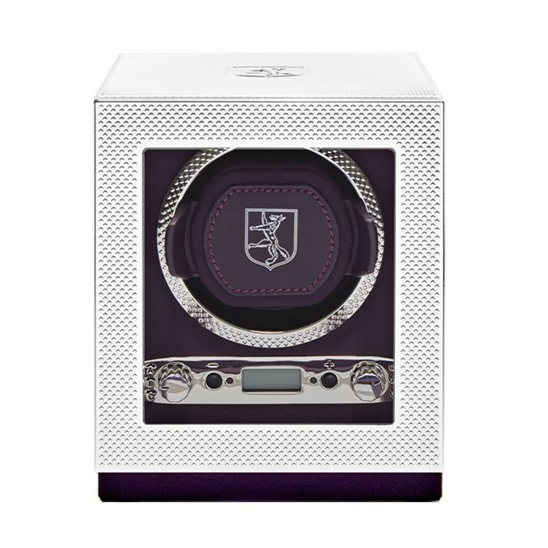 The WOLF 1834 Single Watch Winder Silver by WOLF features a white, textured exterior with a glass front that showcases a purple interior, a circular watch holder adorned with the brand’s stylized logo, and a digital control panel at the bottom offering power reserve setting options.