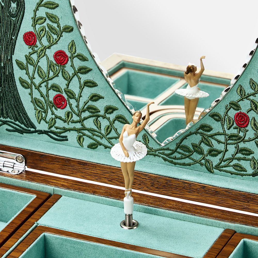 A close-up of the WOLF 1834 Ballet Musical Jewellery Box - Sleeping Beauty in walnut wood shows teal velvet lining, embroidered roses, and a ballerina figurine in a white tutu dancing before a mirror inside this enchanting WOLF jewellery box.