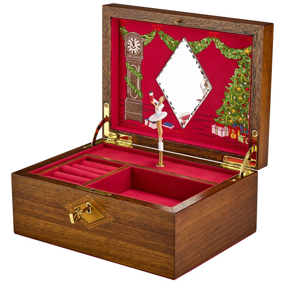 Introducing the WOLF 1834 Nutcracker Musical Box Jewelry Box in rich walnut—a timeless piece by WOLF. This elegant wooden box features a red velvet interior and a delicate ballerina figurine that twirls gracefully before a mirror. Inside the lid, enchanting Christmas details such as a tree, clock, and wrapped gifts add festive charm. A beautiful musical jewellery box that makes a cherished addition to any collection.