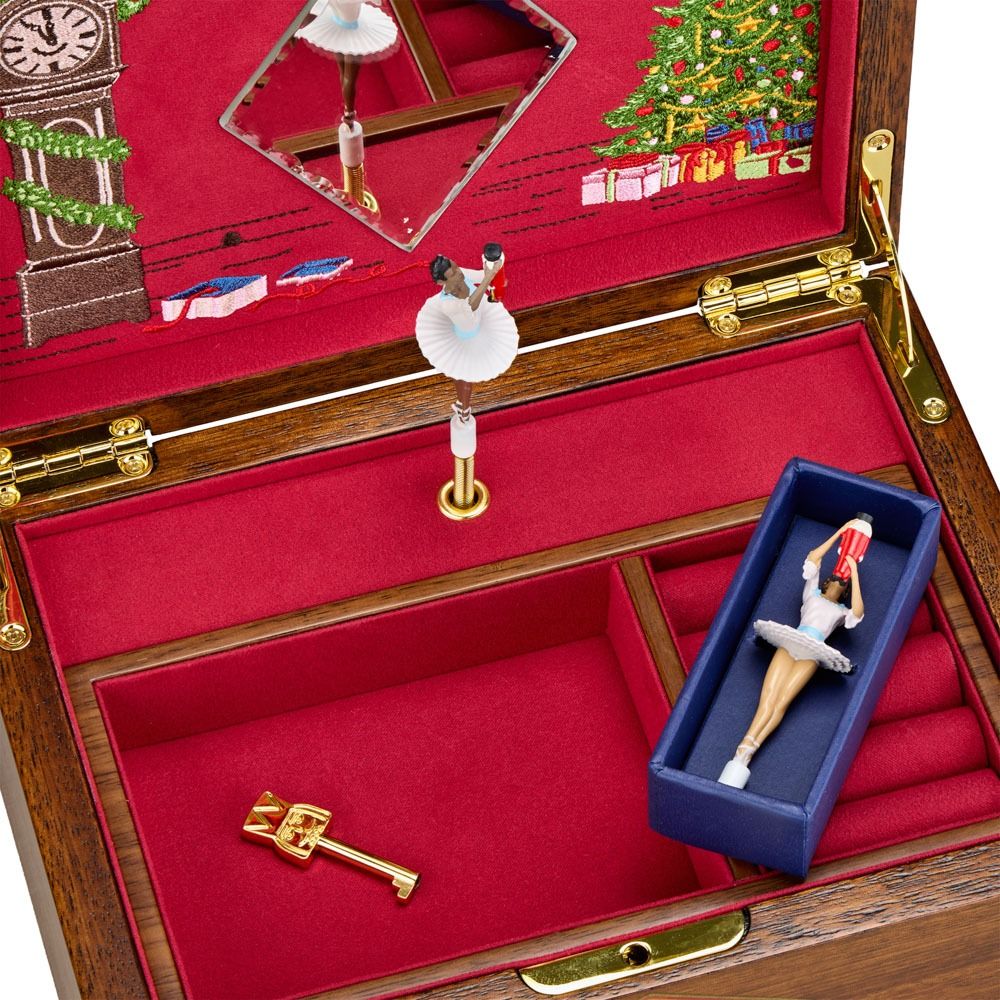 The WOLF 1834 Nutcracker Musical Box Jewelry Box in walnut features an open wooden design with red velvet lining, displaying a spinning ballerina figure, a separate ballerina figure inside a blue ballerina box, a gold key, and embroidered Christmas tree and clock details inside the lid.