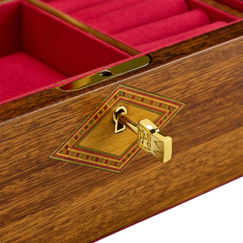 A close-up of a golden key inserted into the WOLF 1834 Nutcracker Musical Box Jewelry Box Walnut, featuring a rich wooden exterior with red velvet lining and a decorative diamond-shaped inlay surrounding the keyhole, evoking the timeless charm of a classic musical jewelry box by WOLF.
