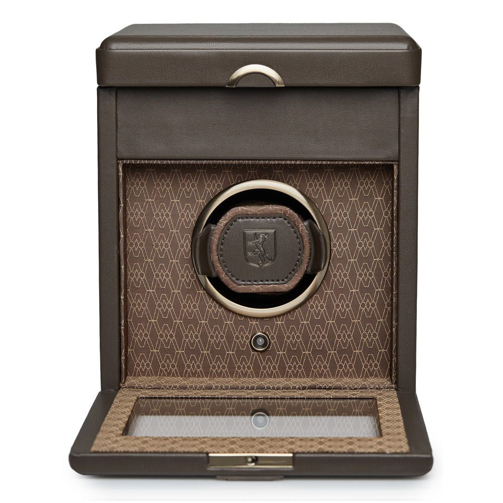 The WOLF 1834 Earth Single Watch Winder, crafted from brown leather and featuring a patterned interior, is open to reveal a cushioned compartment tailored for holding a watch. Its lid includes a transparent window, and the device offers customizable rotation settings as part of its patented innovation, adding sophistication to this elegant accessory from WOLF.