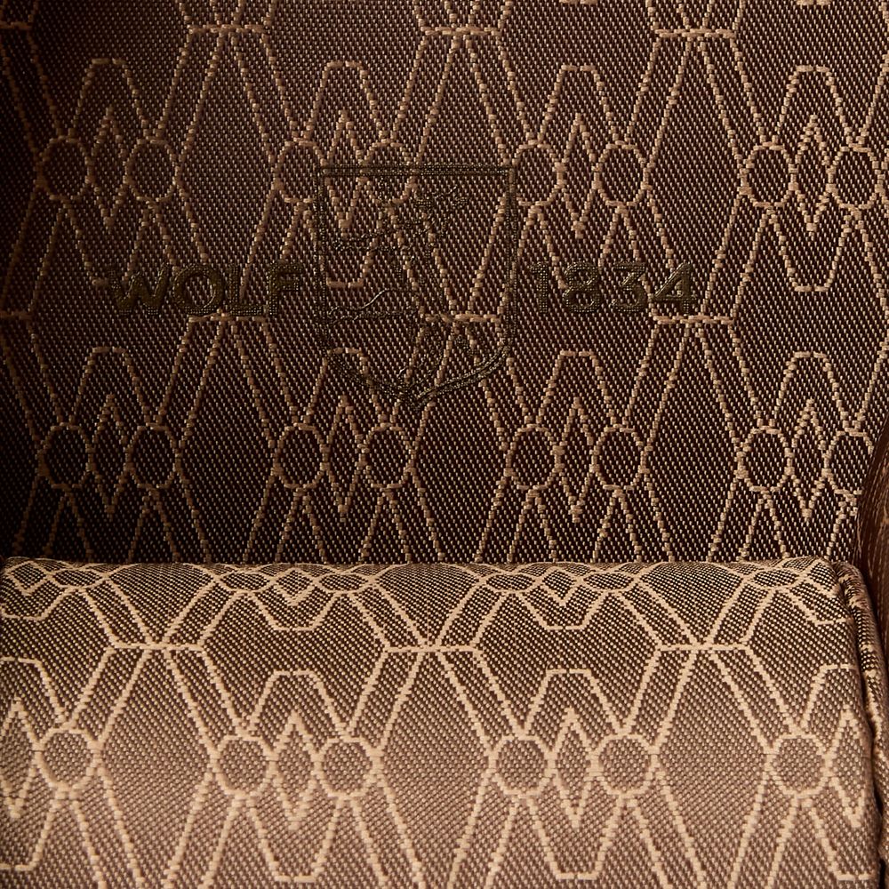 Close-up of textured brown fabric with a geometric pattern and the "WOLF 1834" logo subtly embroidered—an elegant detail from the WOLF 1834 Earth Triple Watch Roll by WOLF.