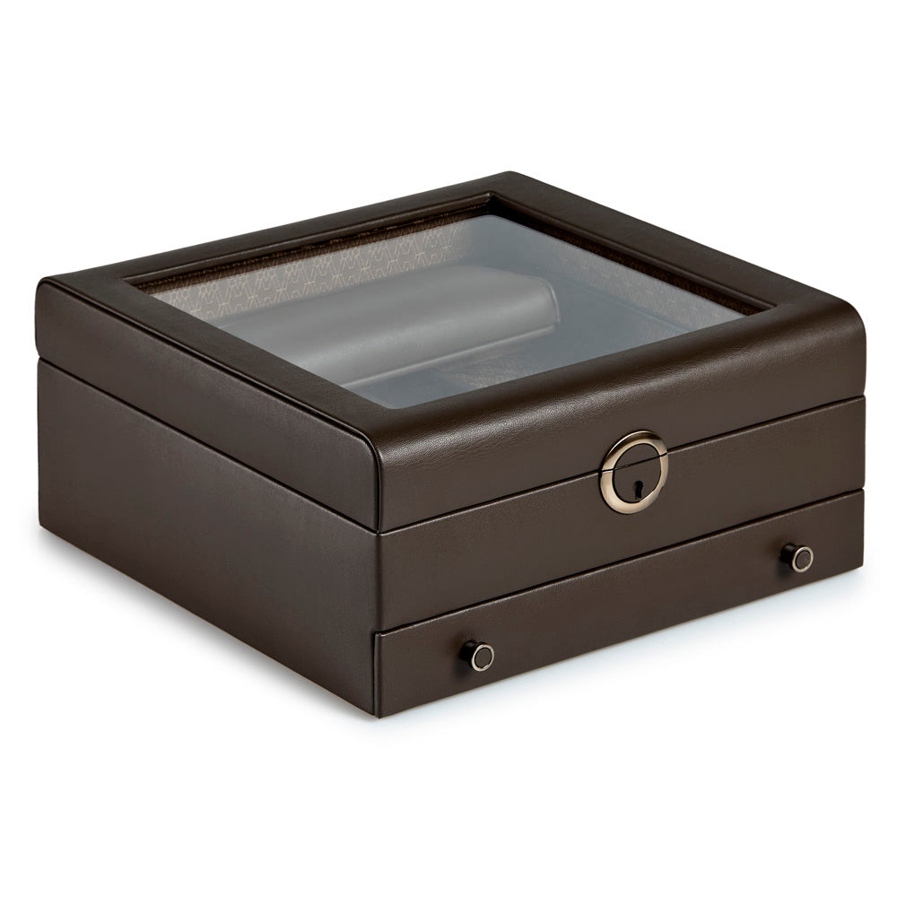The WOLF 1834 Earth Watch Stand Box features a closed, square design in dark brown leather with a clear glass top and a secure lock and key system in the front metal keyhole. With the addition of two small knobs on the bottom drawer, this sleek piece perfectly combines style with watch storage functionality.