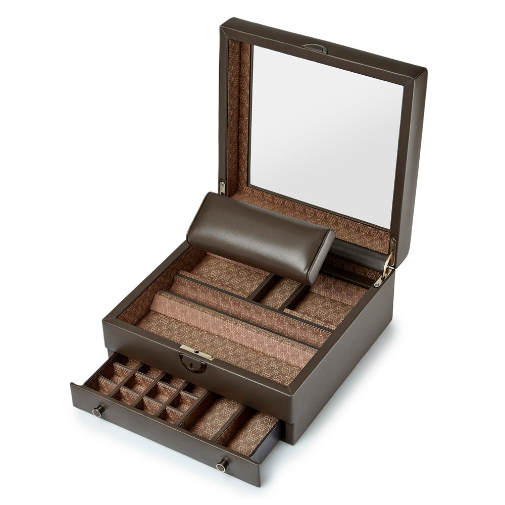 A WOLF 1834 Earth Watch Stand Box by WOLF, featuring a brown leather exterior and an open lid that reveals a mirror inside. It offers multiple compartments lined with patterned fabric for organizing jewelry, including slots for rings and a retractable watch stand, providing secure storage sections for necklaces and other accessories.