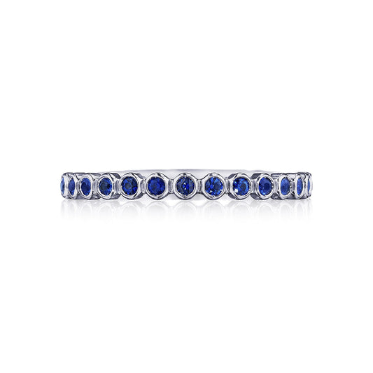 The Tacori Sculpted Crescent 18K White Gold Round Brilliant Bezel Droplet Sapphire Anniversary Ring by Tacori showcases a continuous row of blue sapphires in a refined bezel setting against a silver-like background.