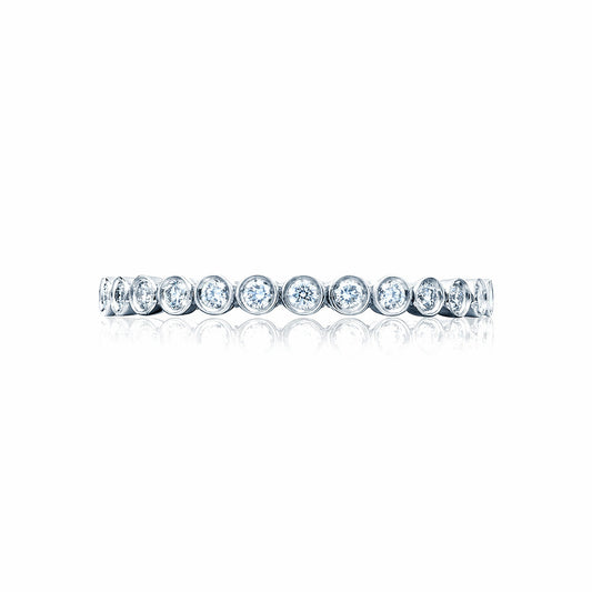 The Tacori Sculpted Crescent 18K White Gold Round Brilliant Bezel Droplet Diamond Anniversary Ring elegantly showcases a series of round, bezel-set gemstones encircling the band, reminiscent of timeless engagement rings, beautifully displayed against a white background.