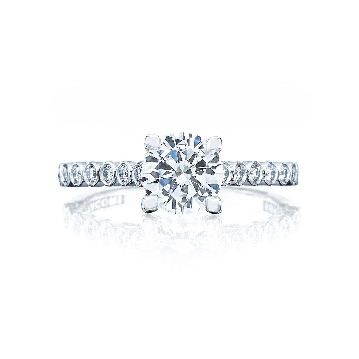 The Tacori Sculpted Crescent 18K White Gold Round Brilliant Semi Mount Solitaire Engagement Ring with Diamond Band exemplifies the timeless allure of diamond engagement rings. Featuring an elegant design, this piece showcases a large round center diamond surrounded by smaller diamonds along the band. Displayed against a white background with a subtle reflection beneath, it exudes sophistication and style.