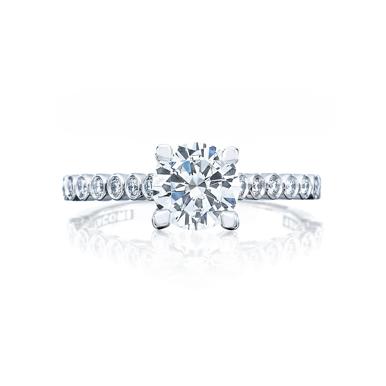 The Tacori Sculpted Crescent 18K White Gold Round Brilliant Semi Mount Solitaire Engagement Ring with Diamond Band exemplifies the timeless allure of diamond engagement rings. Featuring an elegant design, this piece showcases a large round center diamond surrounded by smaller diamonds along the band. Displayed against a white background with a subtle reflection beneath, it exudes sophistication and style.