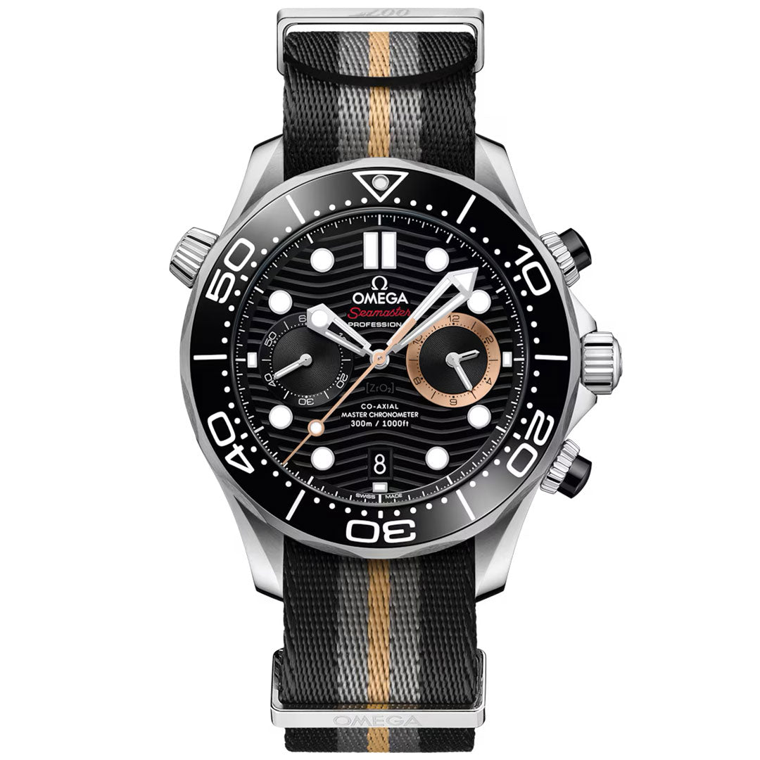 Introducing the OMEGA Seamaster Diver 300M 007 First Light Edition Co-Axial Master Chronometer Chronograph 44mm Watch—a luxurious timepiece featuring a striking black dial, white markers, refined gold accents, and a sophisticated black fabric strap with a central gold stripe. This elegant chronograph from OMEGA displays the time and date, while offering precise subdials for enhanced functionality.