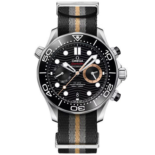 Introducing the OMEGA Seamaster Diver 300M 007 First Light Edition Co-Axial Master Chronometer Chronograph 44mm Watch—a luxurious timepiece featuring a striking black dial, white markers, refined gold accents, and a sophisticated black fabric strap with a central gold stripe. This elegant chronograph from OMEGA displays the time and date, while offering precise subdials for enhanced functionality.