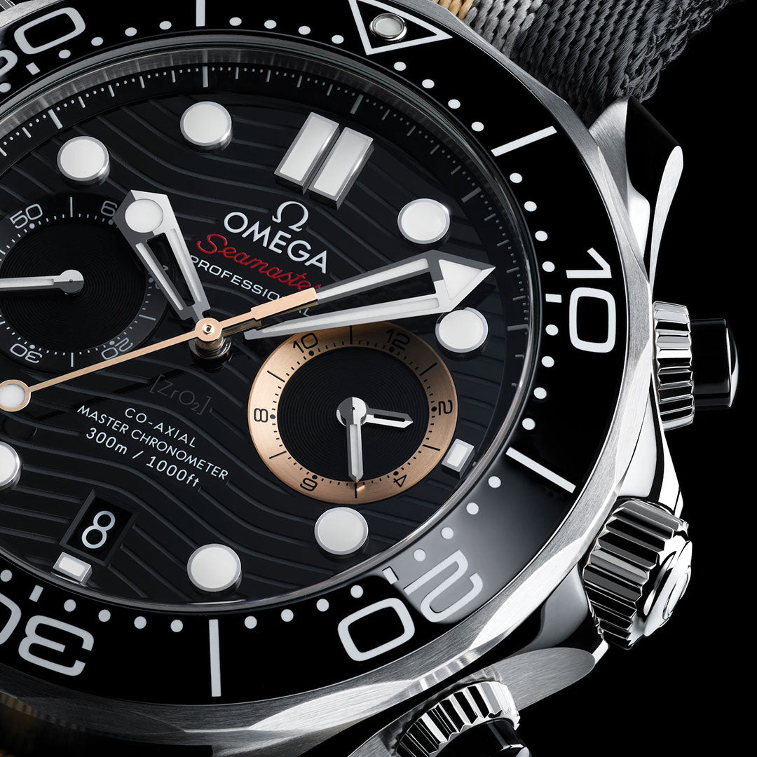 Close-up of the OMEGA Seamaster Diver 300M 007 First Light Edition Co-Axial Master Chronometer Chronograph 44mm watch face, highlighting its black and silver accents, chronograph subdials, bold white hour markers, and distinctive wavy textured patterns.