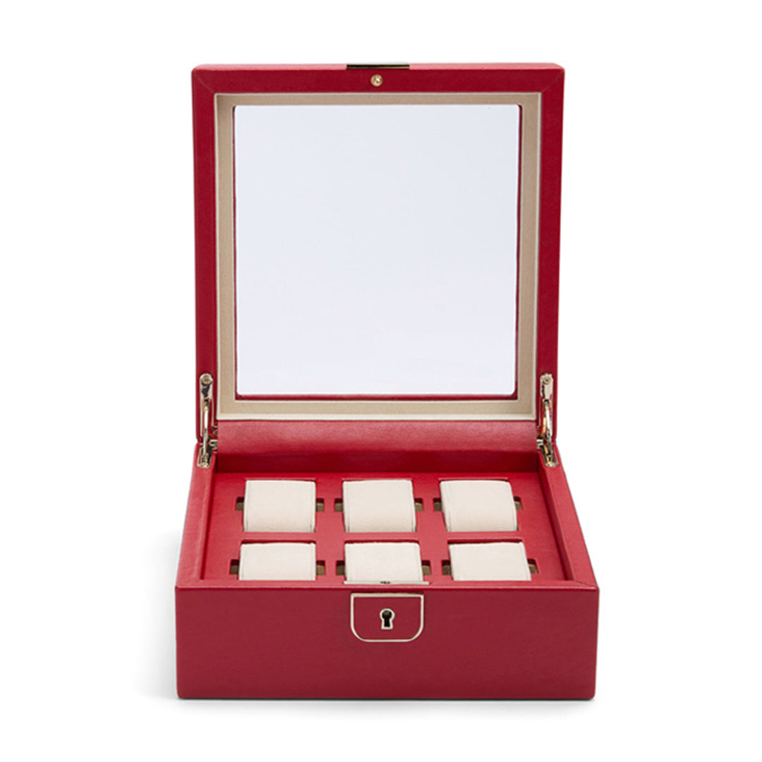 The WOLF 1834 Palermo 6 Piece Watch Box by WOLF is designed in a striking red, featuring a reflective lid that opens to reveal six cushioned compartments perfect for displaying your watch collection. It boasts a gold clasp in the front, ensuring lock and key security for safeguarding your treasured timepieces.