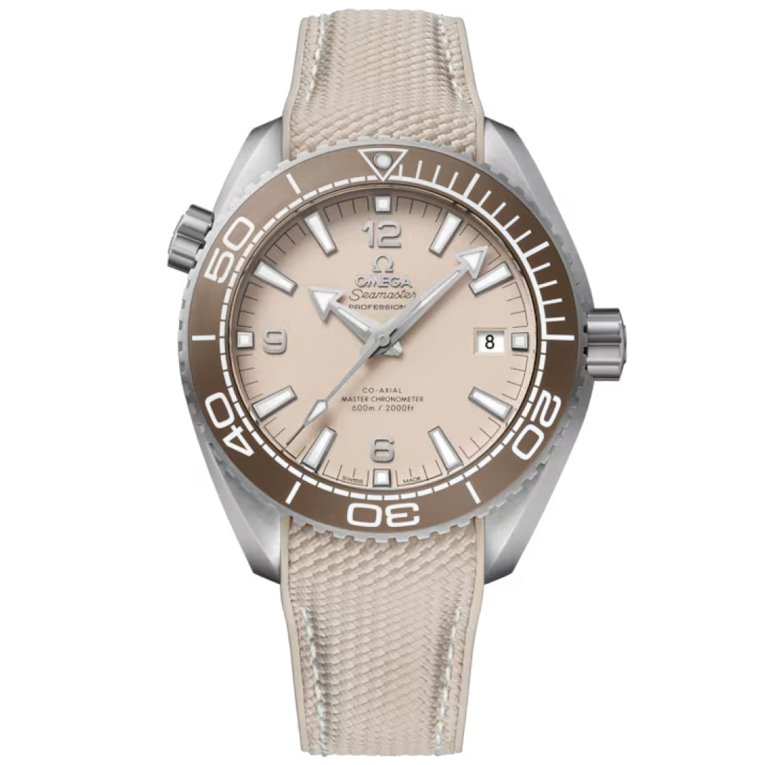 The OMEGA Seamaster Planet Ocean 600M Co-Axial Master Chronometer 43.5mm features a beige dial, brown bezel, matching fabric strap, white hour markers, and a date window at 3 o’clock, shown on a plain white background.