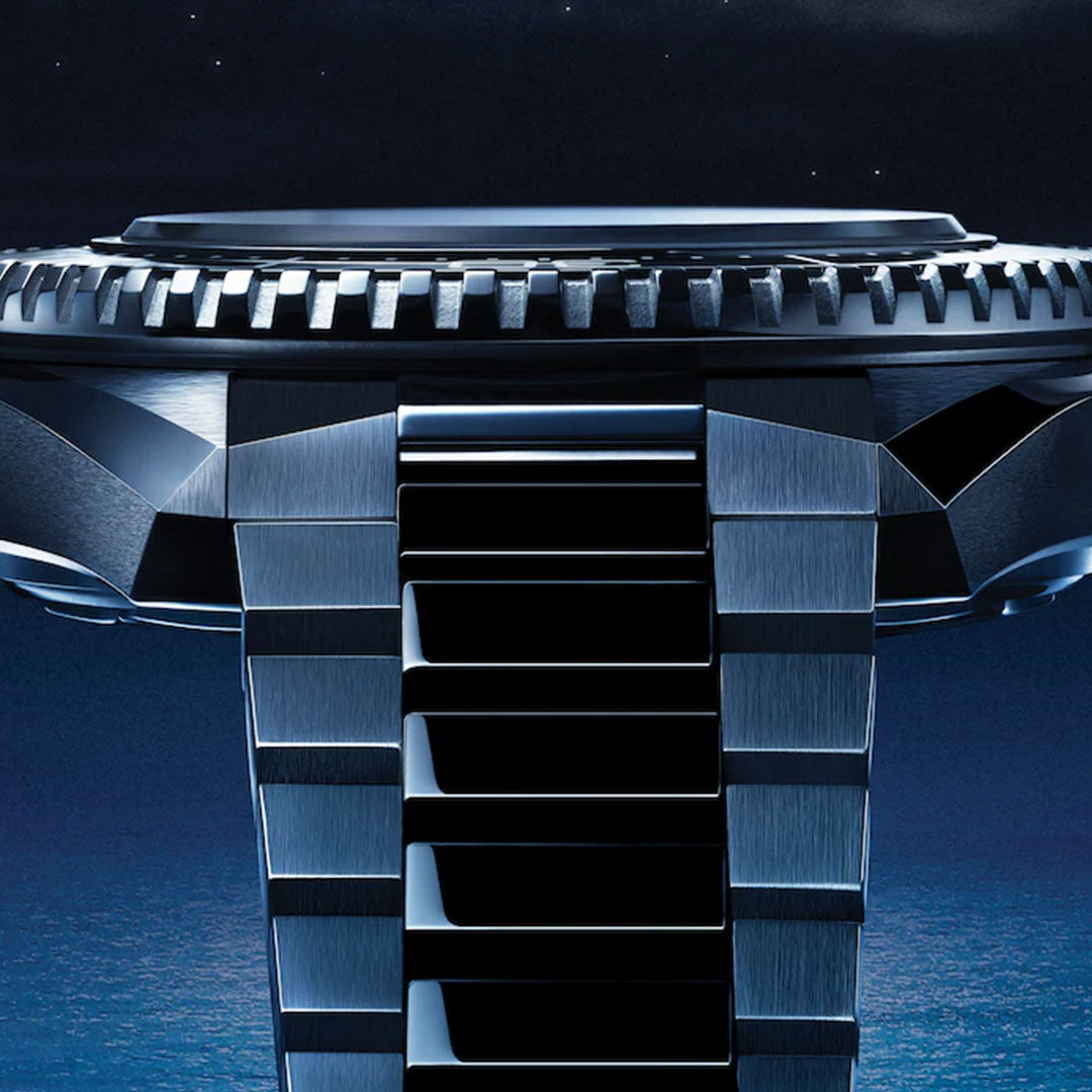 Close-up side view of the OMEGA Seamaster Planet Ocean 600M Co-Axial Master Chronometer 42mm, featuring a metallic strap and ridged bezel, set against a starry night sky and tranquil blue ocean—luxury in its element.