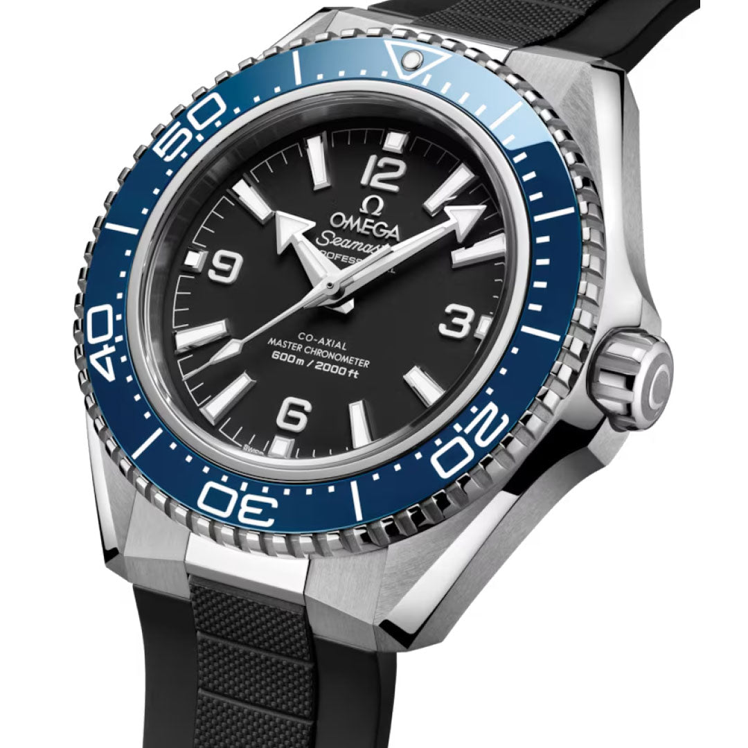 A close-up of the OMEGA Seamaster Planet Ocean 600M Co-Axial Master Chronometer 42mm shows a blue bezel, black dial with white markers, and a black rubber strap; the dial displays “600m/2000ft” water resistance.